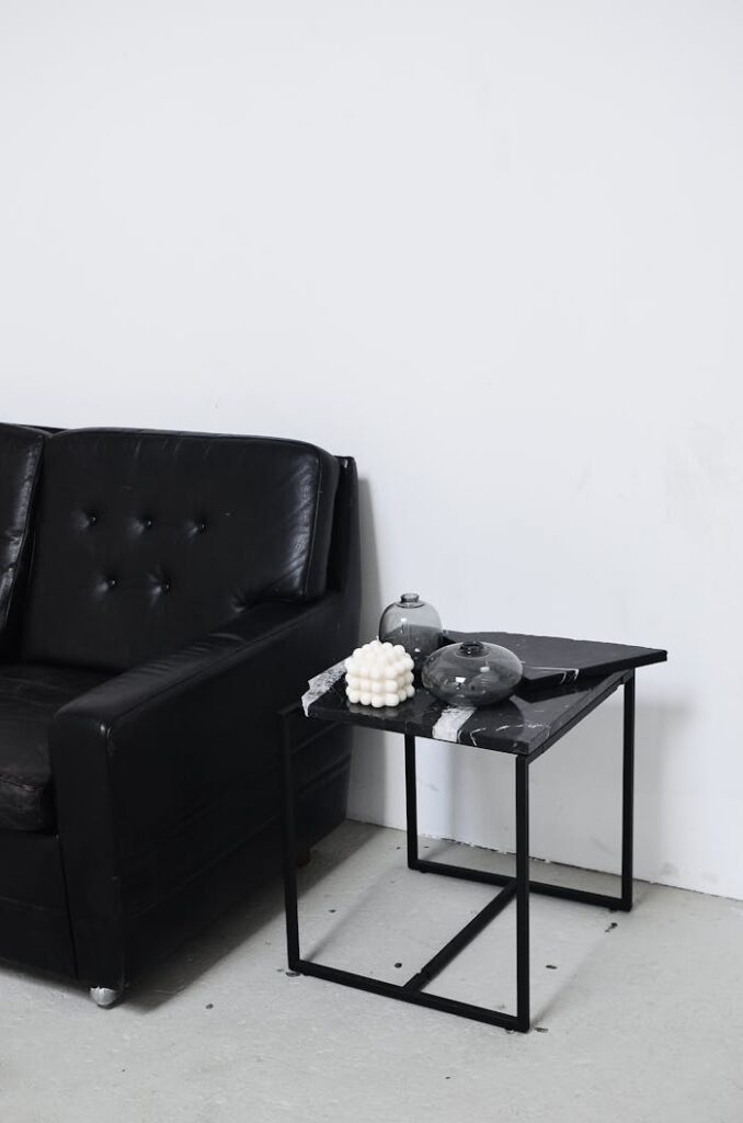 pexels-photo-6044978 Black and white of living room interior with leather sofa near table with decorative candle and vases at home
